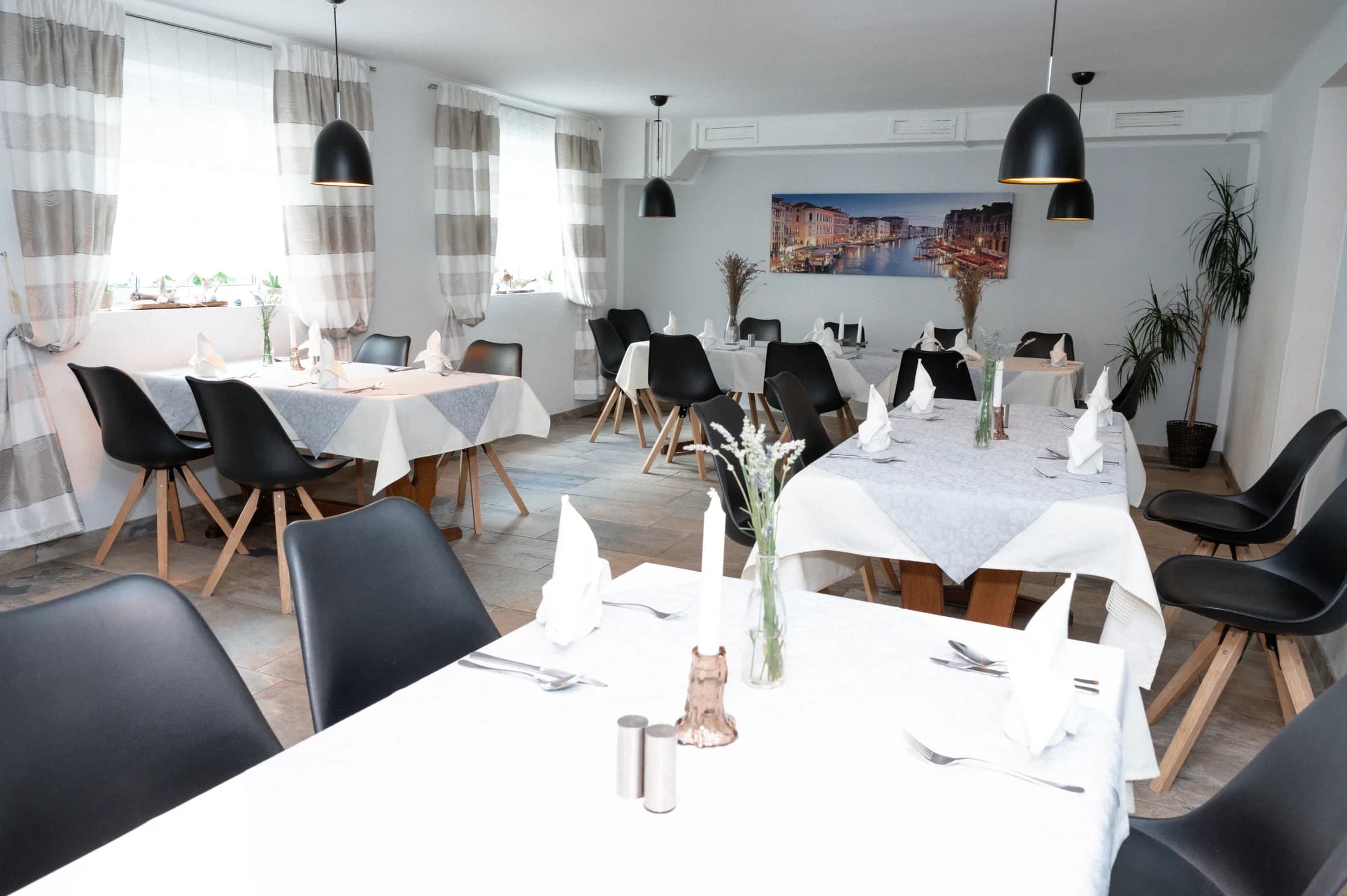 Restaurant-Innenbereich mit eingedeckten Tischen
